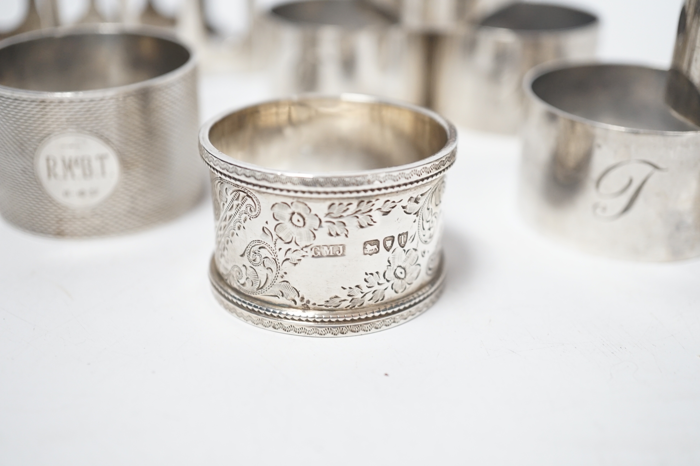 A set of six silver napkin rings, Robert Pringle & Sons, London, 1953, two other silver napkin rings and a silver five bar toast rack, 9.8oz.